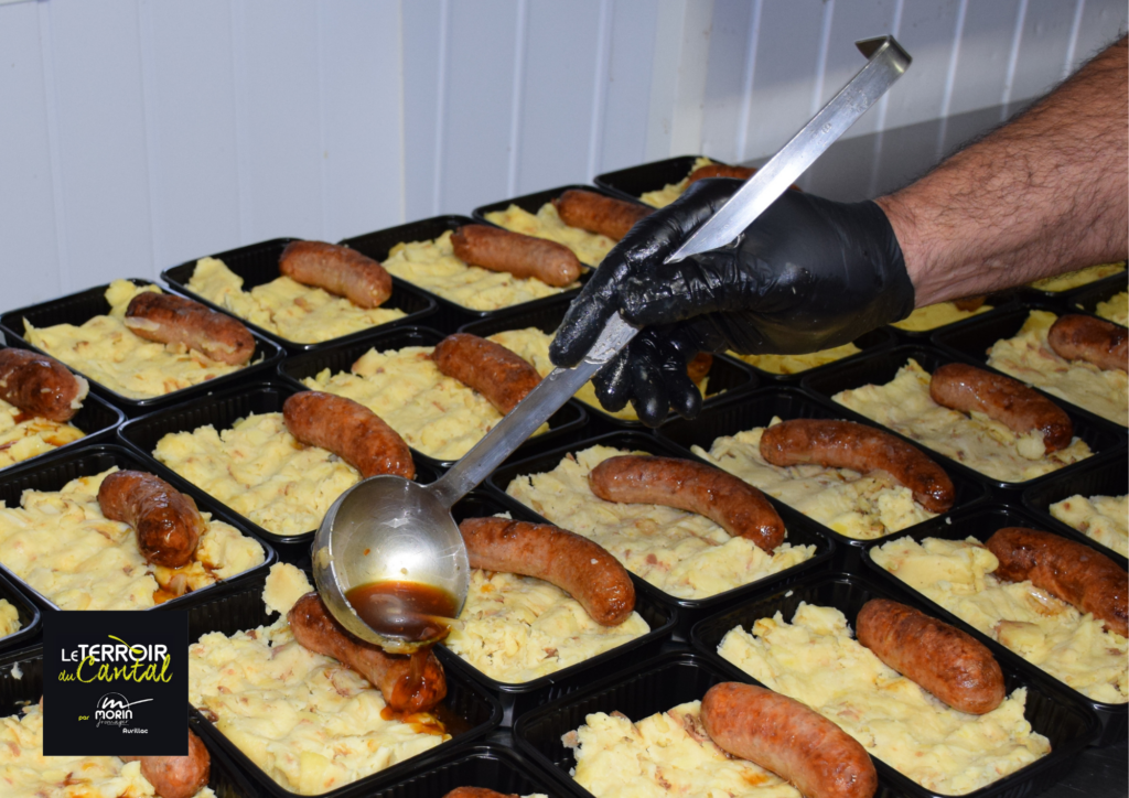 Préparation de la truffade saucisse en barquette individuelle dans notre atelier culinaire "Le Terroir du Cantal" à Aurillac.